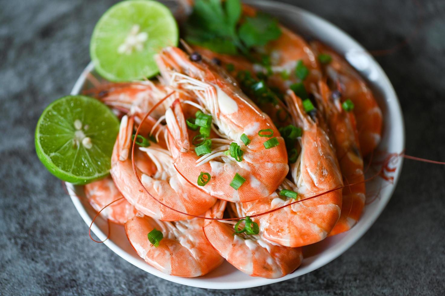 shrimp on white bolw and wooden background dining table food, Fresh shrimps prawns seafood lemon lime with herbs and spice photo