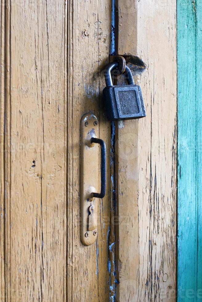 Old closed door with padlock and knob photo