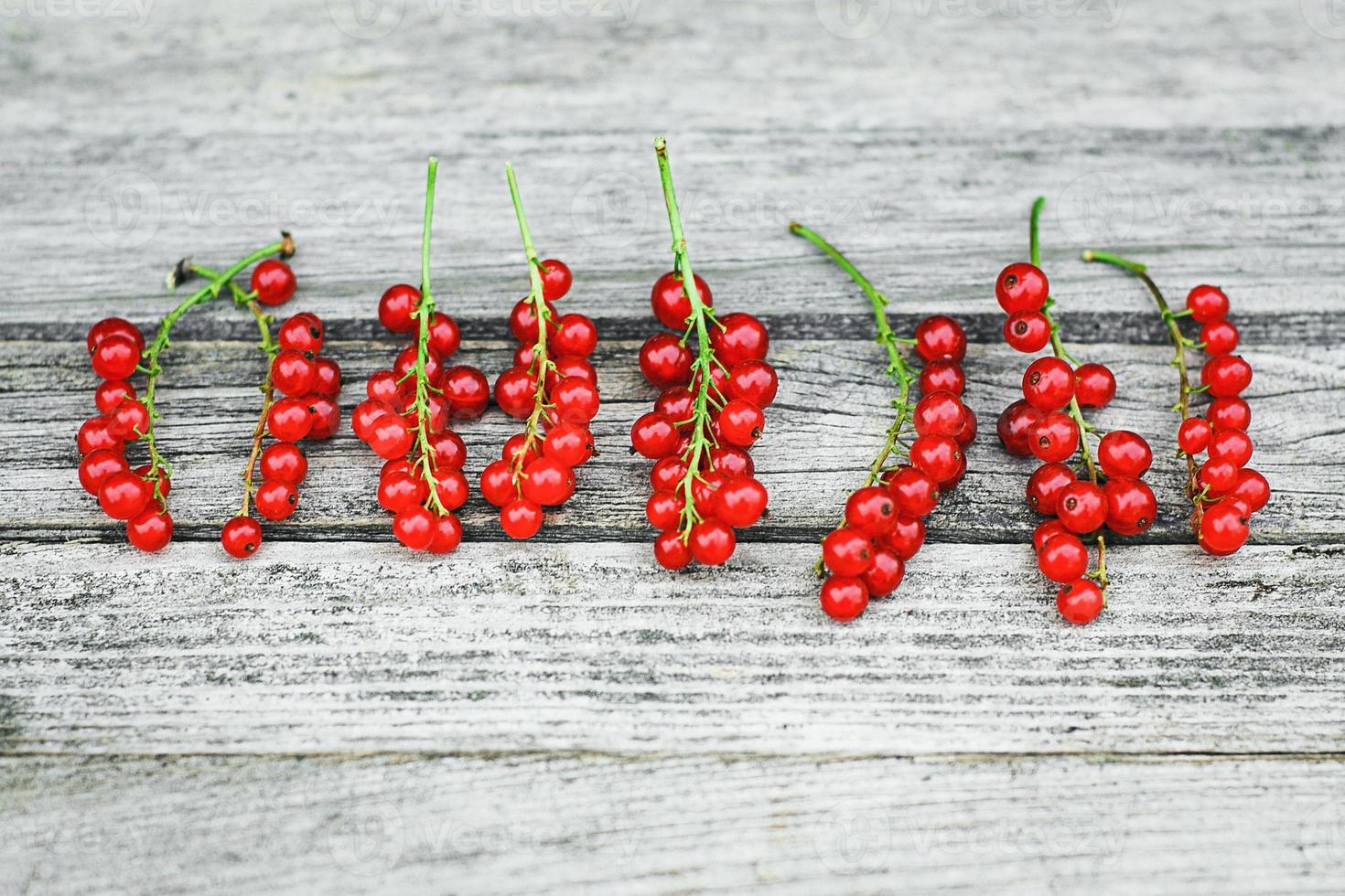 Red currant berries on old gray wooden table photo