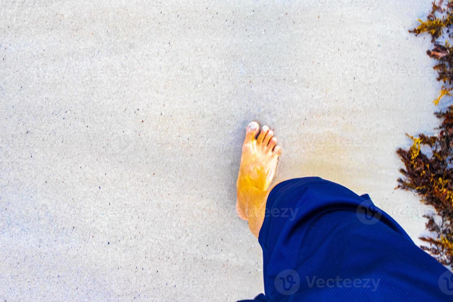 Walking barefoot on the beach sand by the water Mexico. photo