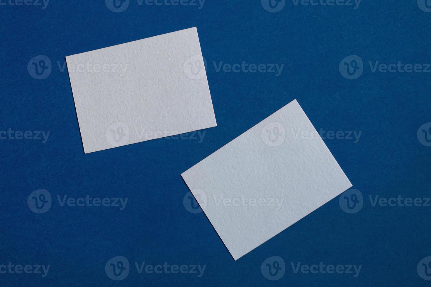 two white sticky notes on blue wall photo