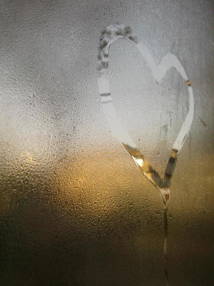 A love heart painted on a misted glass window background photo