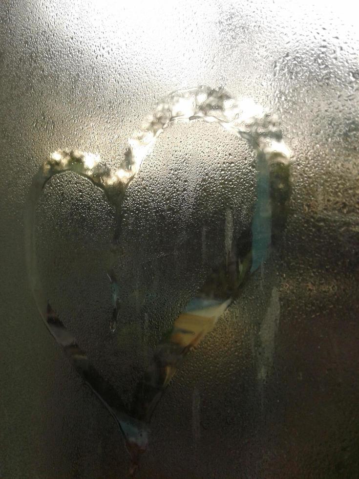 A love heart painted on a misted glass window background photo