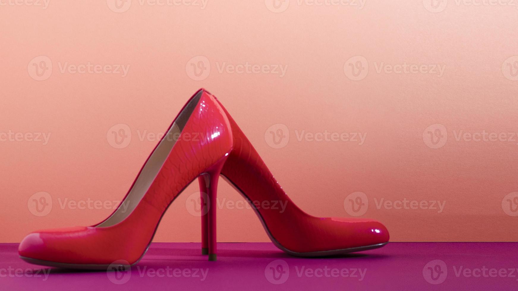 Elegant classic shoes close-up. Bright pink high heeled shoes. Pink and violet background. photo
