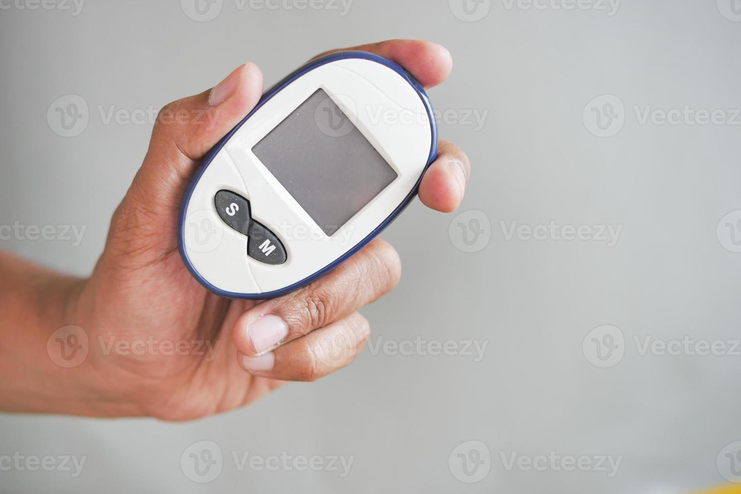 man's hand measuring blood sugar level photo