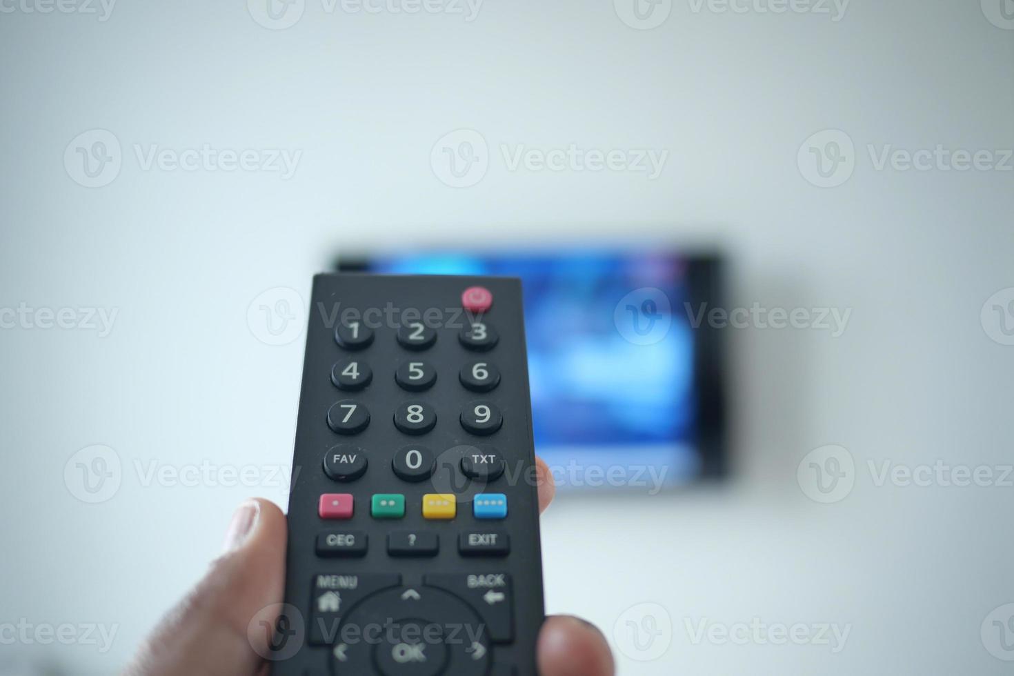 pov shot of man hand holding tv remote. photo