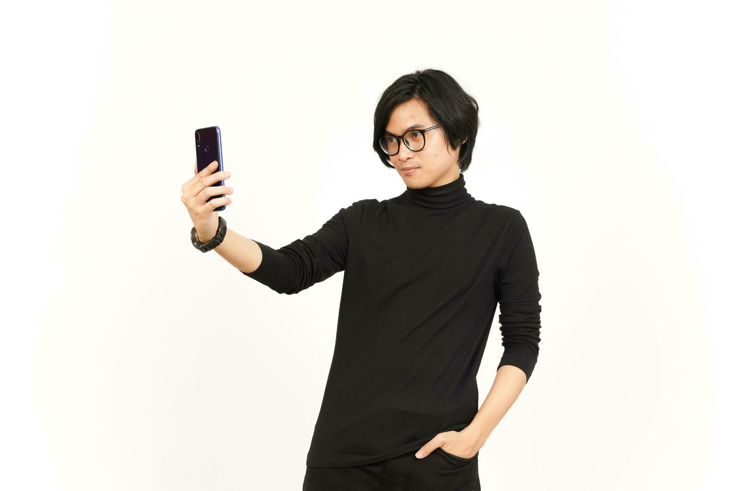 tomar un selfie utilizando teléfono inteligente de hermoso asiático hombre aislado en blanco antecedentes foto