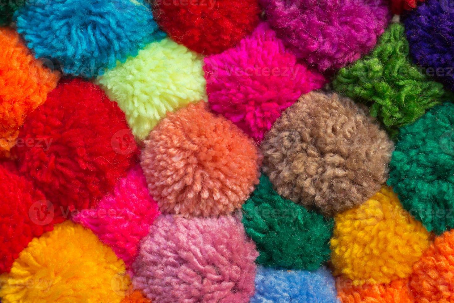 textured background of assorted and multicolored wool pom poms photo