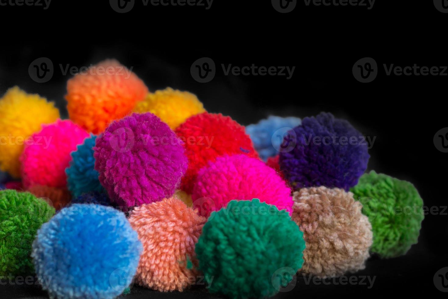 textured background of assorted and multicolored wool pom poms photo