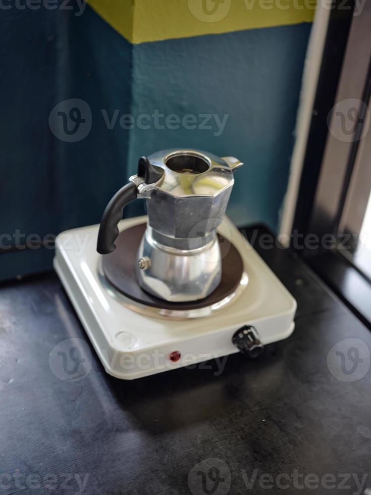 An Italian coffee machine called a moka pot on stove photo