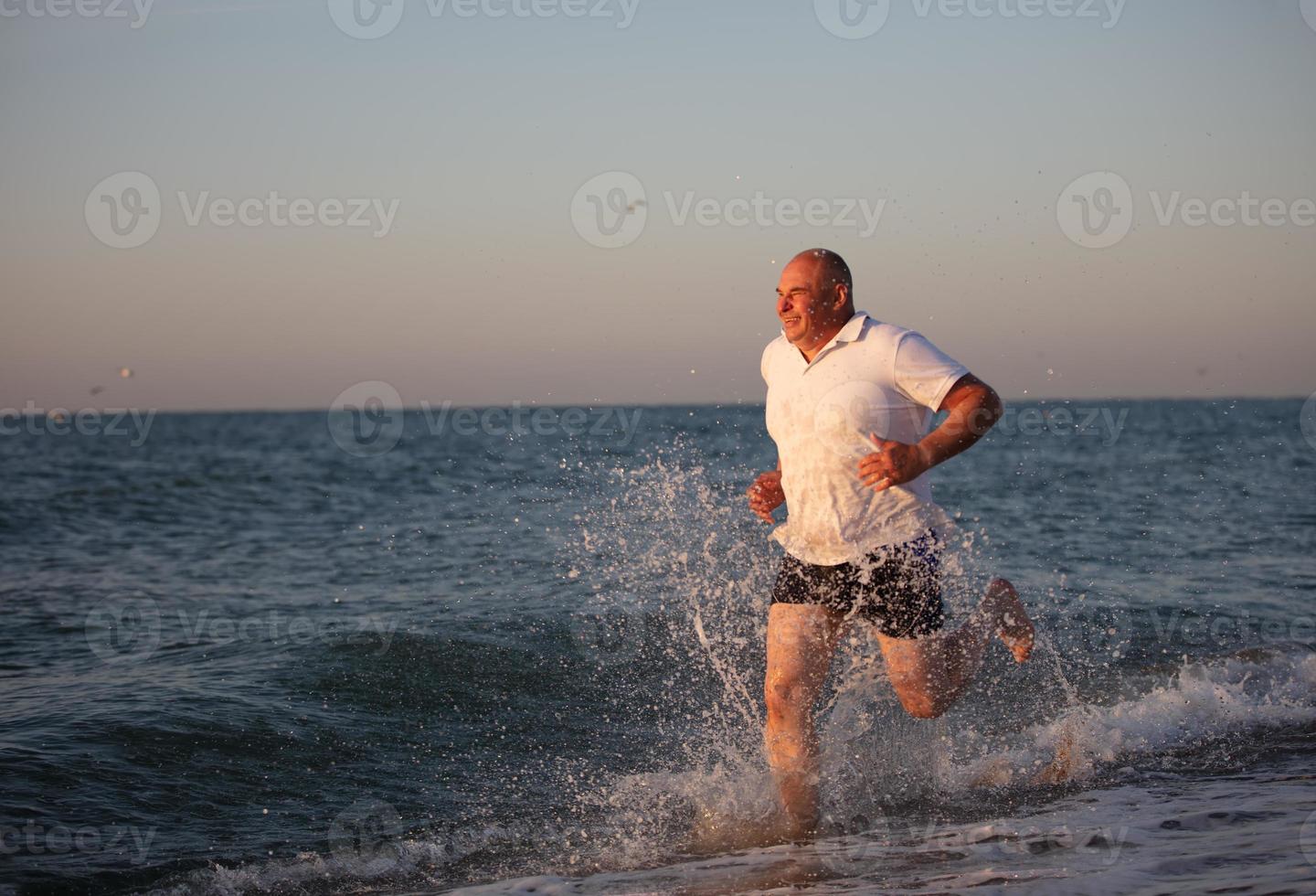 An adult man runs along the coast. photo