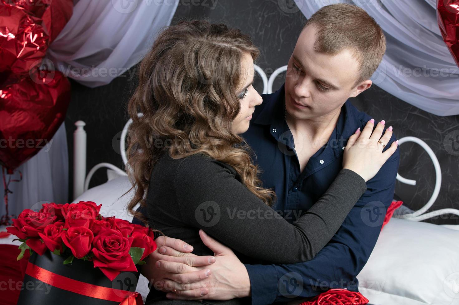 amoroso Pareja desde parte superior a abajo. hombre y mujer con rojo rosas en el dormitorio. hermosa joven marido y esposa.de cerca hombre y mujer abrazando.valentine's día. foto