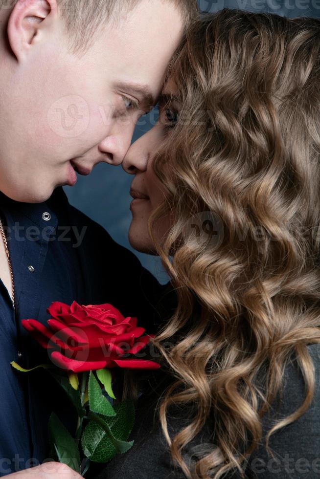 perfil de un hermosa niña y chico con un rojo Rosa en el chico hombro. San Valentín día. amantes romántico fecha. foto