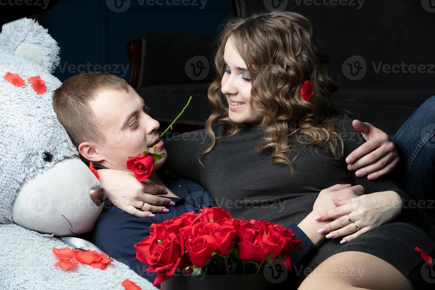 Lovers on Valentine's Day. Young couple with a soft bear and a red rose. Beautiful couple on a date. photo