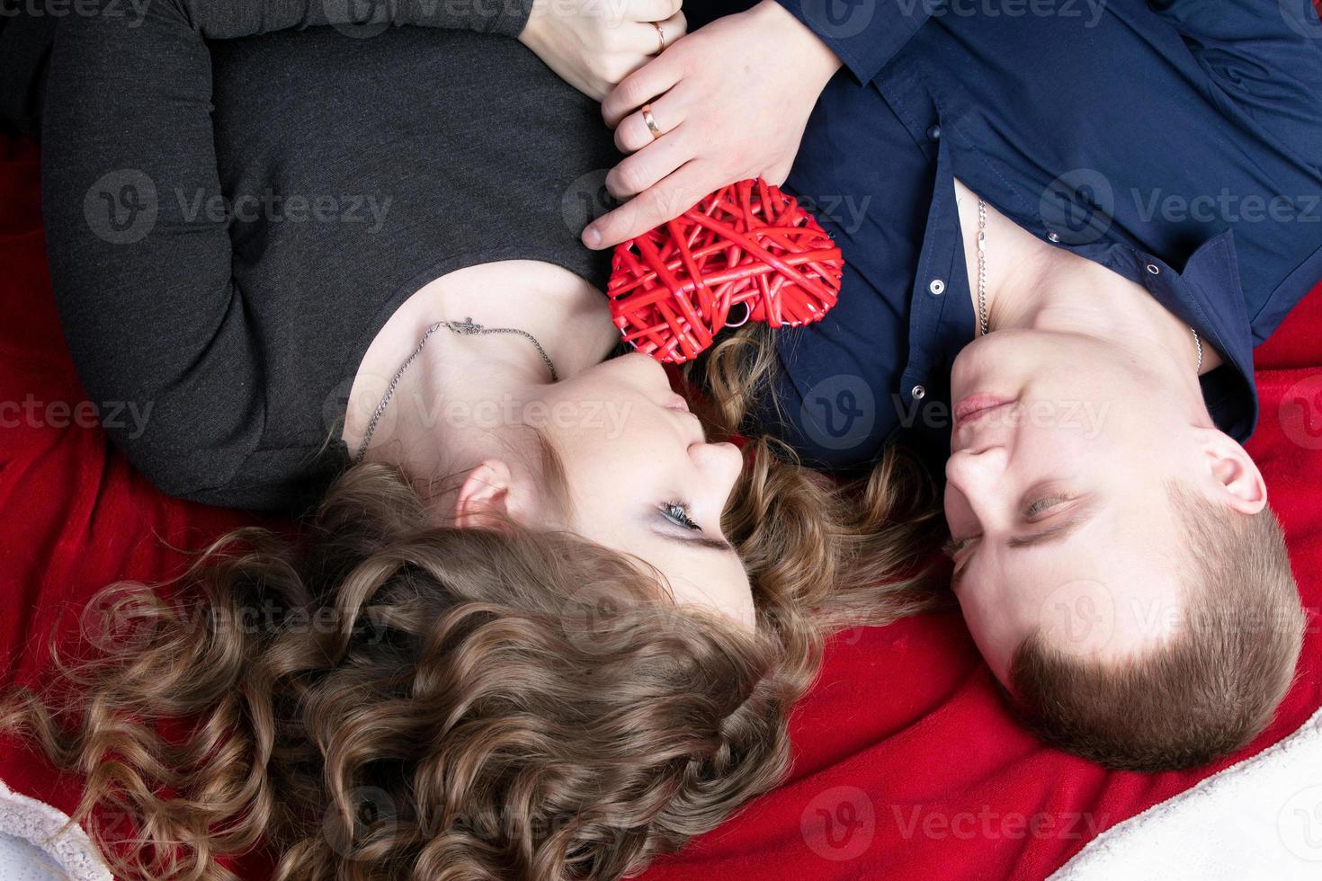 amoroso Pareja desde parte superior a abajo. hombre y mujer con un rojo corazón. hermosa joven marido y esposa.de cerca hombre y mujer juntos.valentine's día. foto