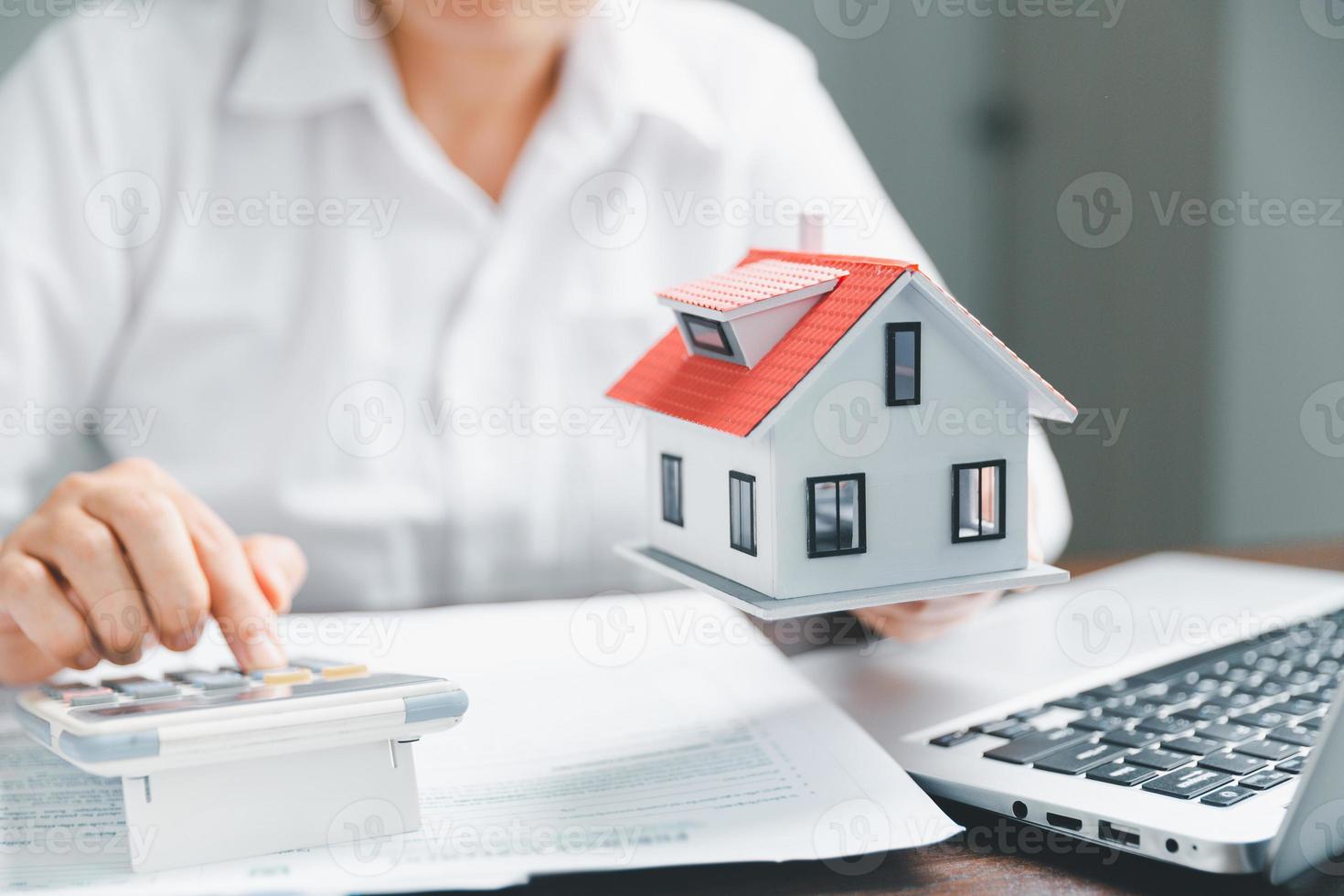 Real estate agents offer contracts to purchase or rent residential. Business person hands holding home model, small building red house. Mortgage property insurance moving home and real estate concept photo