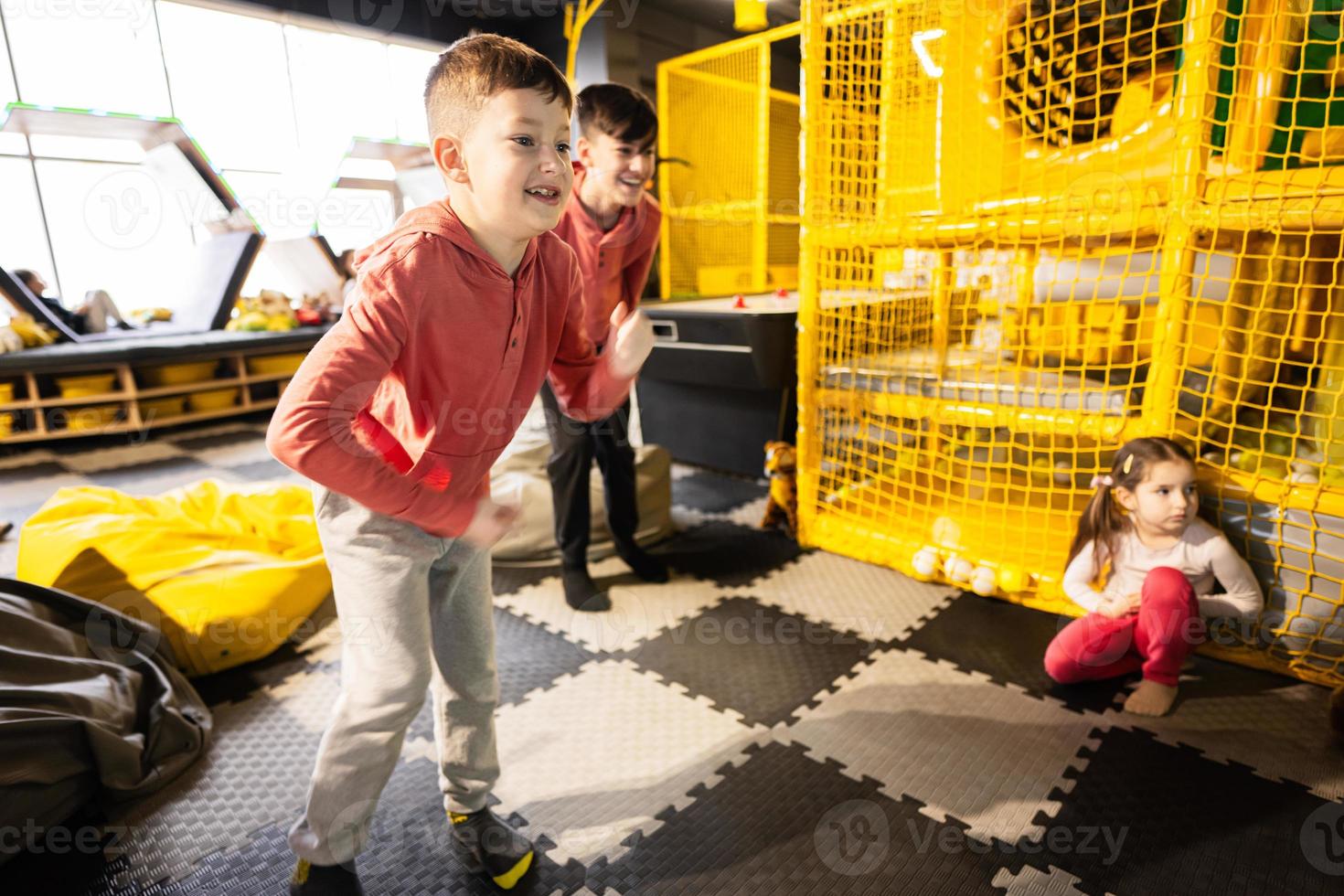 Two brothers riding with modern video game console by sensor at kids play center. photo