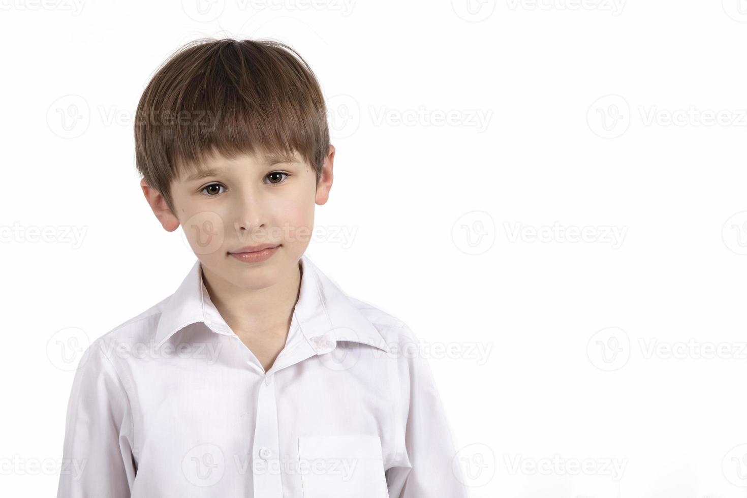 retrato de un Siete año antiguo chico en un blanco antecedentes. primario colegio alumno. hermosa niño en un blanco camisa . foto