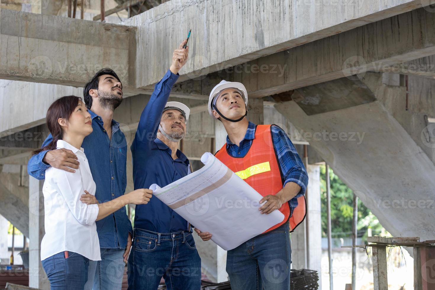 Newly wed couple is meeting with engineering contractor at their under construction house to inspect the building progress and quality control for home ownership and real estate development concept photo