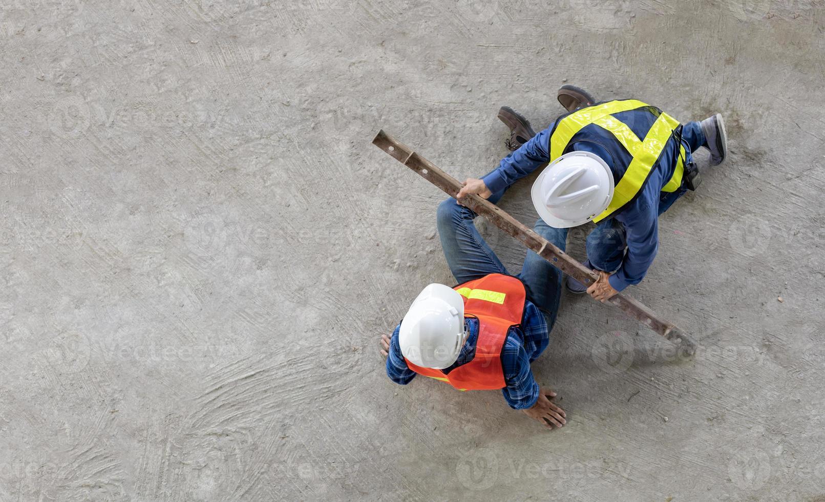 industrial fábrica trabajador teniendo accidente mientras trabajando en fabricación sitio mientras su colega es Ayudar para la seguridad lugar de trabajo y emergencia concepto foto