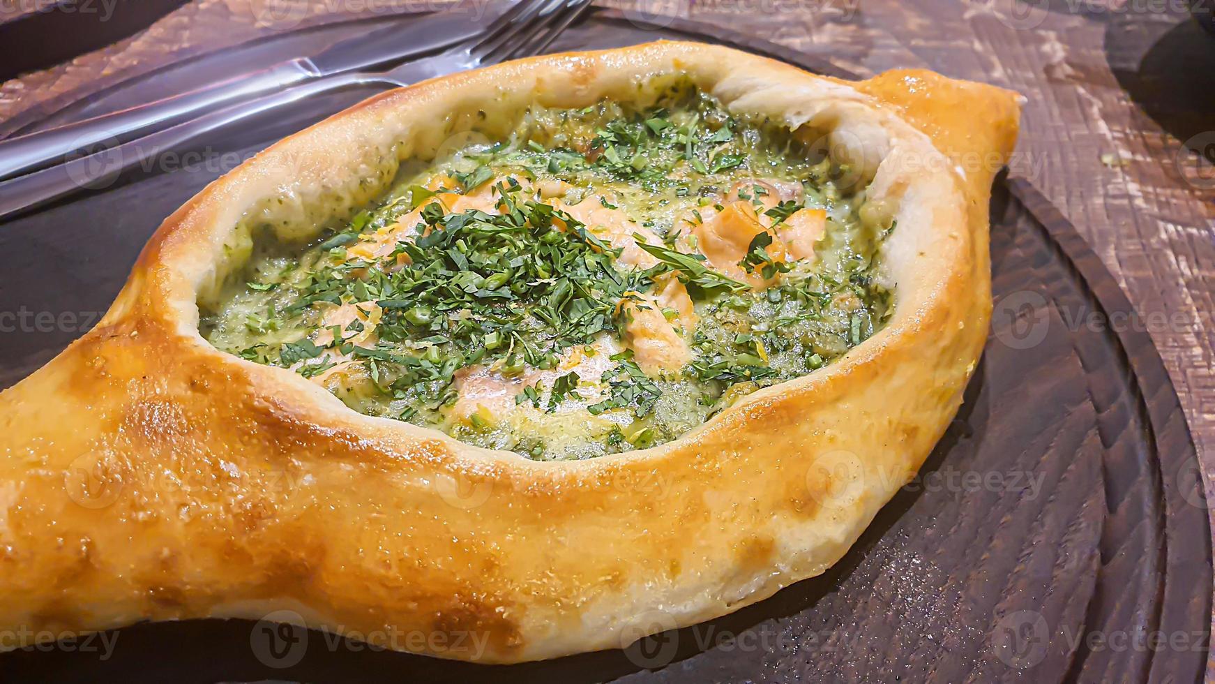 Georgian pastry dish. Pie with red fish and spinach. photo