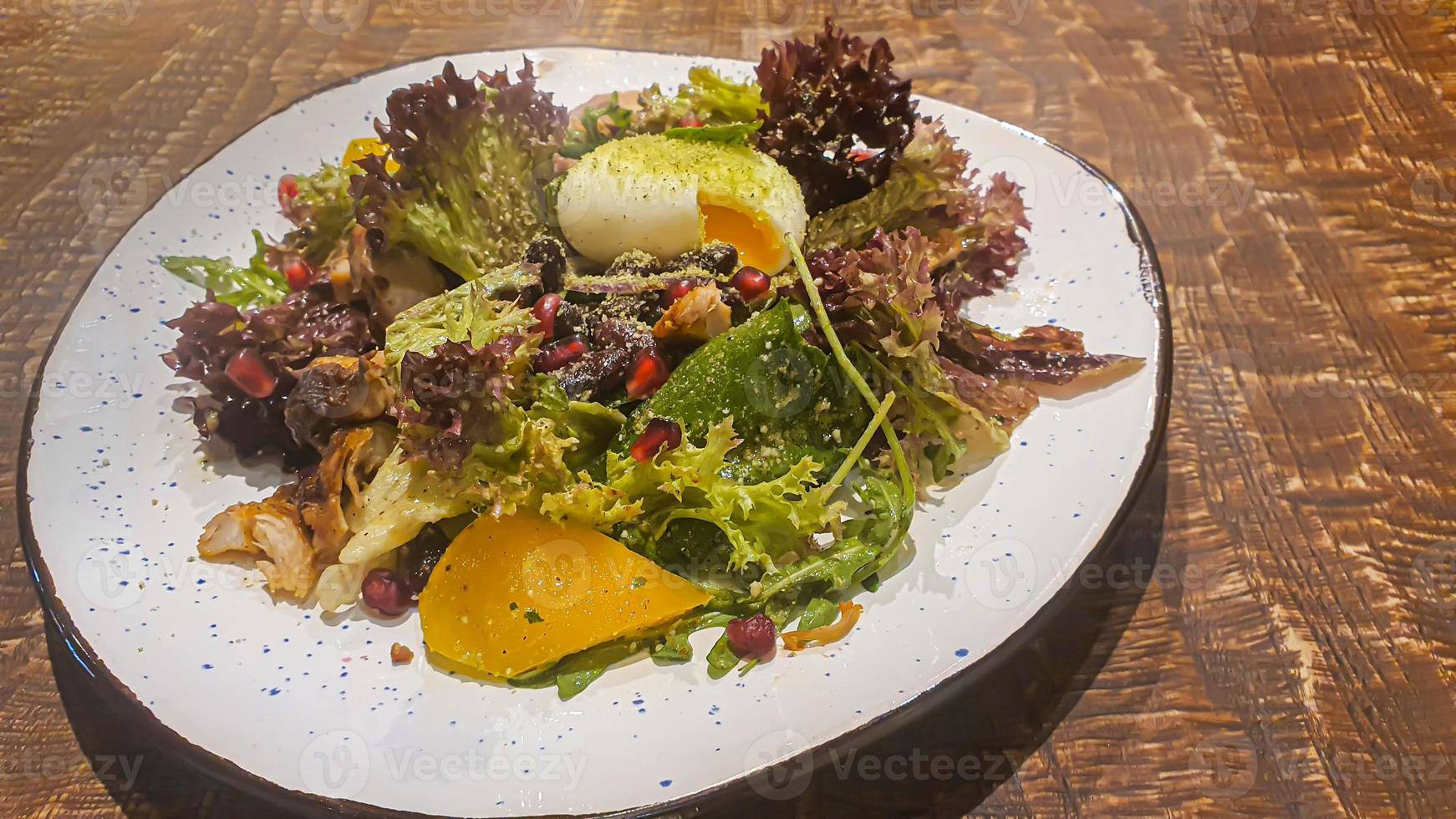 Diet salad of fresh vegetables. Lettuce, poached egg, tomatoes, green onions and chili peppers. Sauce. photo