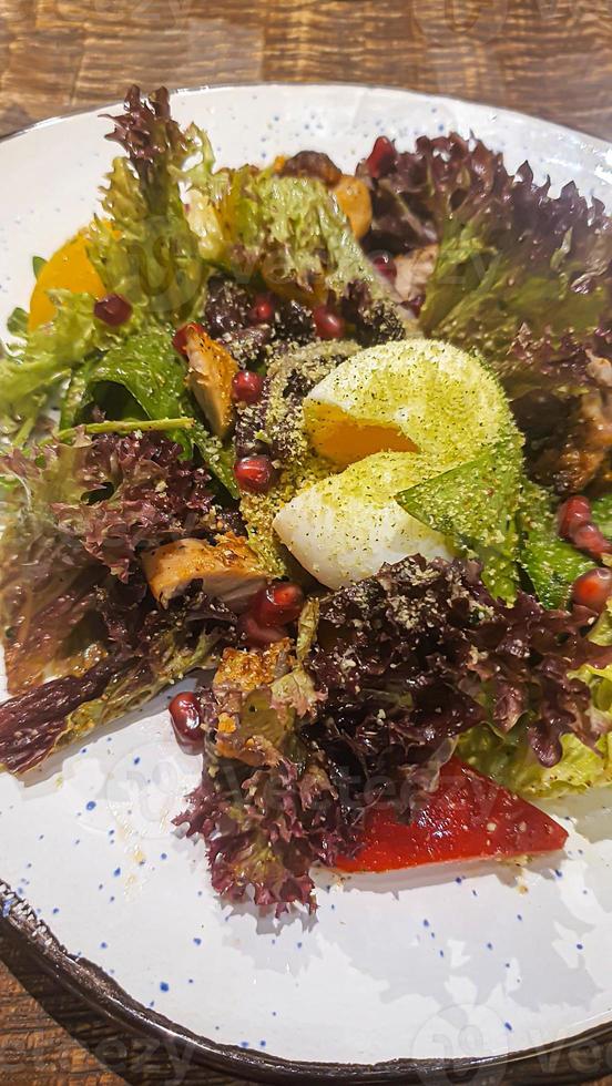 Diet salad of fresh vegetables. Lettuce, poached egg, tomatoes, green onions and chili peppers. Sauce. photo