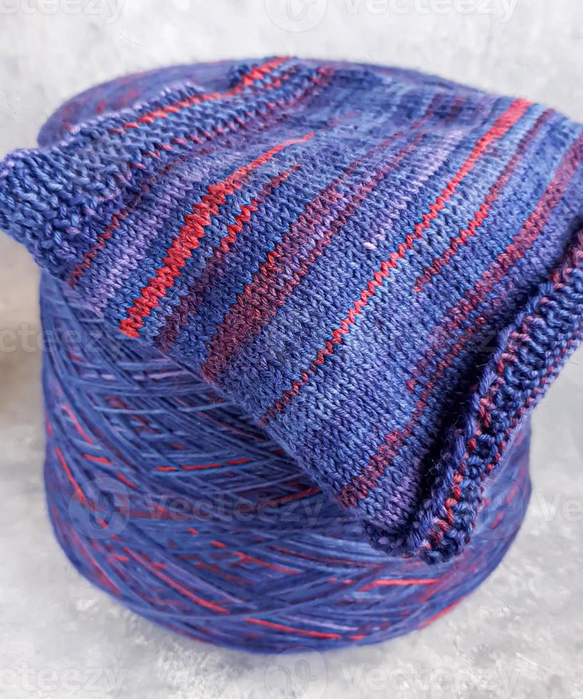 Handmade knitting pattern. Knitted fabric from a multi-colored thread and a large bobbin. photo