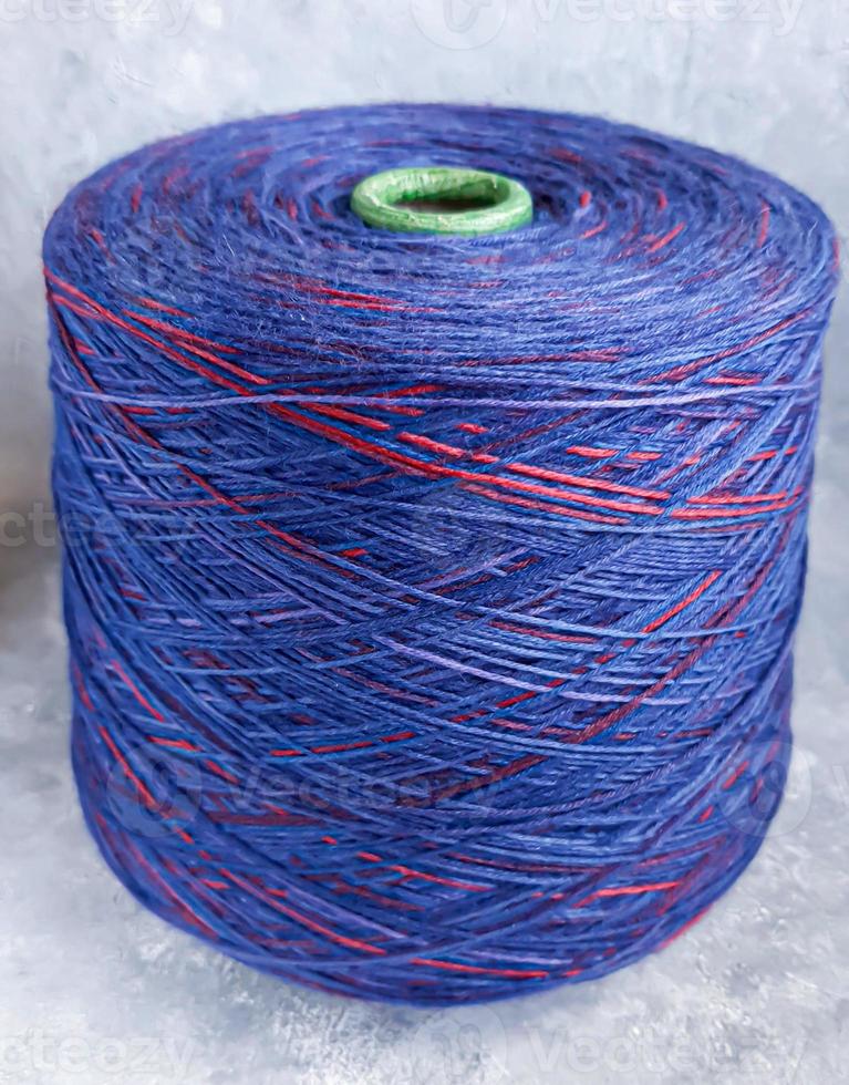 Handmade knitting pattern. Knitted fabric from a multi-colored thread and a large bobbin. photo