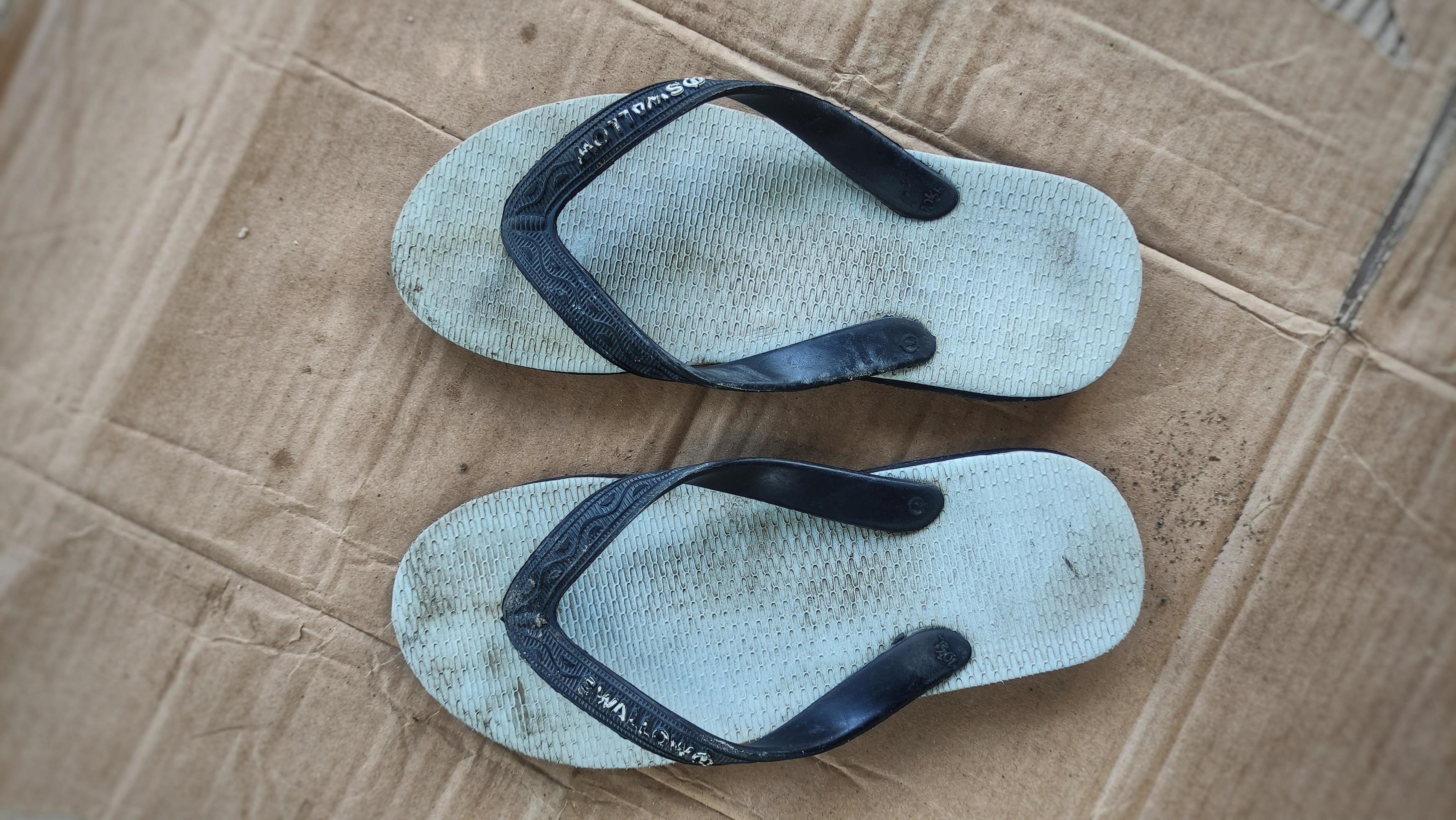 dirty white flip flops after being used from activities 22372555