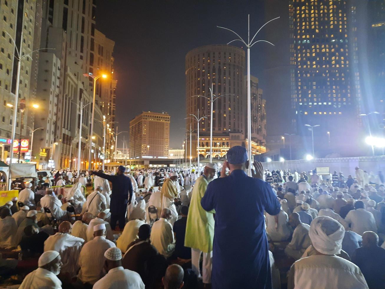 Mecca, Saudi Arabia, April 2023 - A beautiful view of pilgrims, tall buildings and lights at night on the outer road in Masjid al-Haram, Mecca. photo