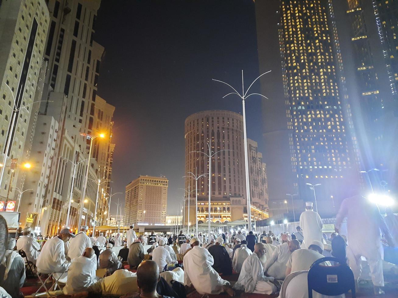 Mecca, Saudi Arabia, April 2023 - A beautiful view of pilgrims, tall buildings and lights at night on the outer road in Masjid al-Haram, Mecca. photo