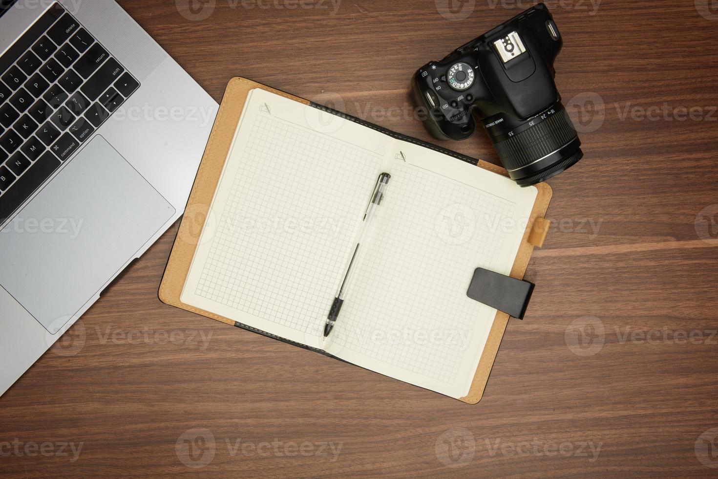 camera and laptop on wooden table photo