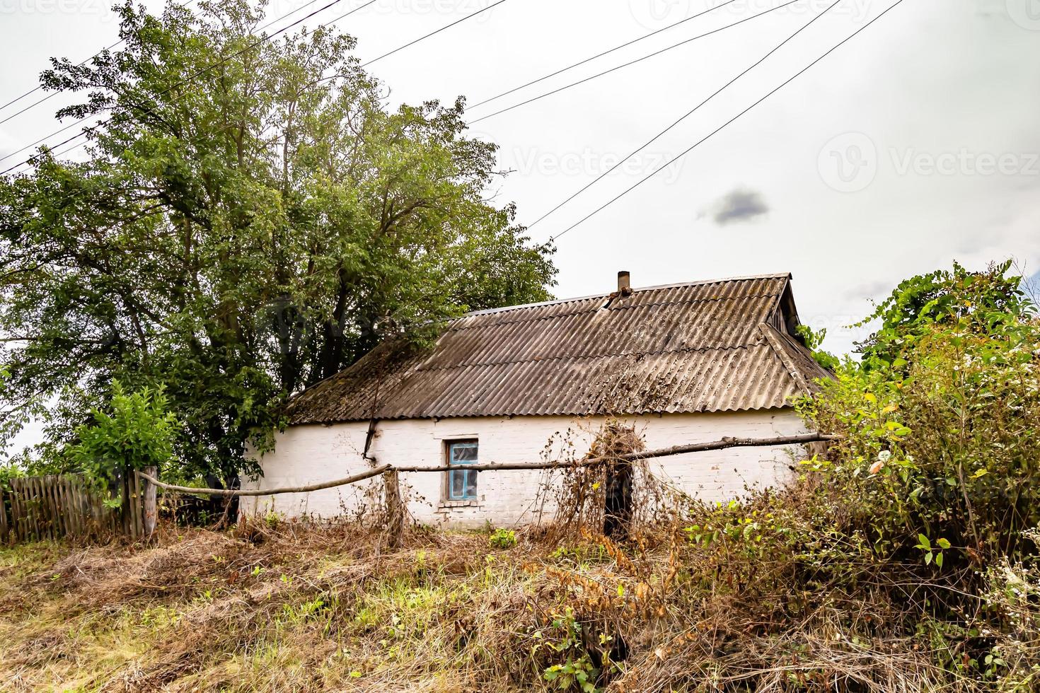 hermosa y antigua casa de campo abandonada en el campo sobre fondo natural foto