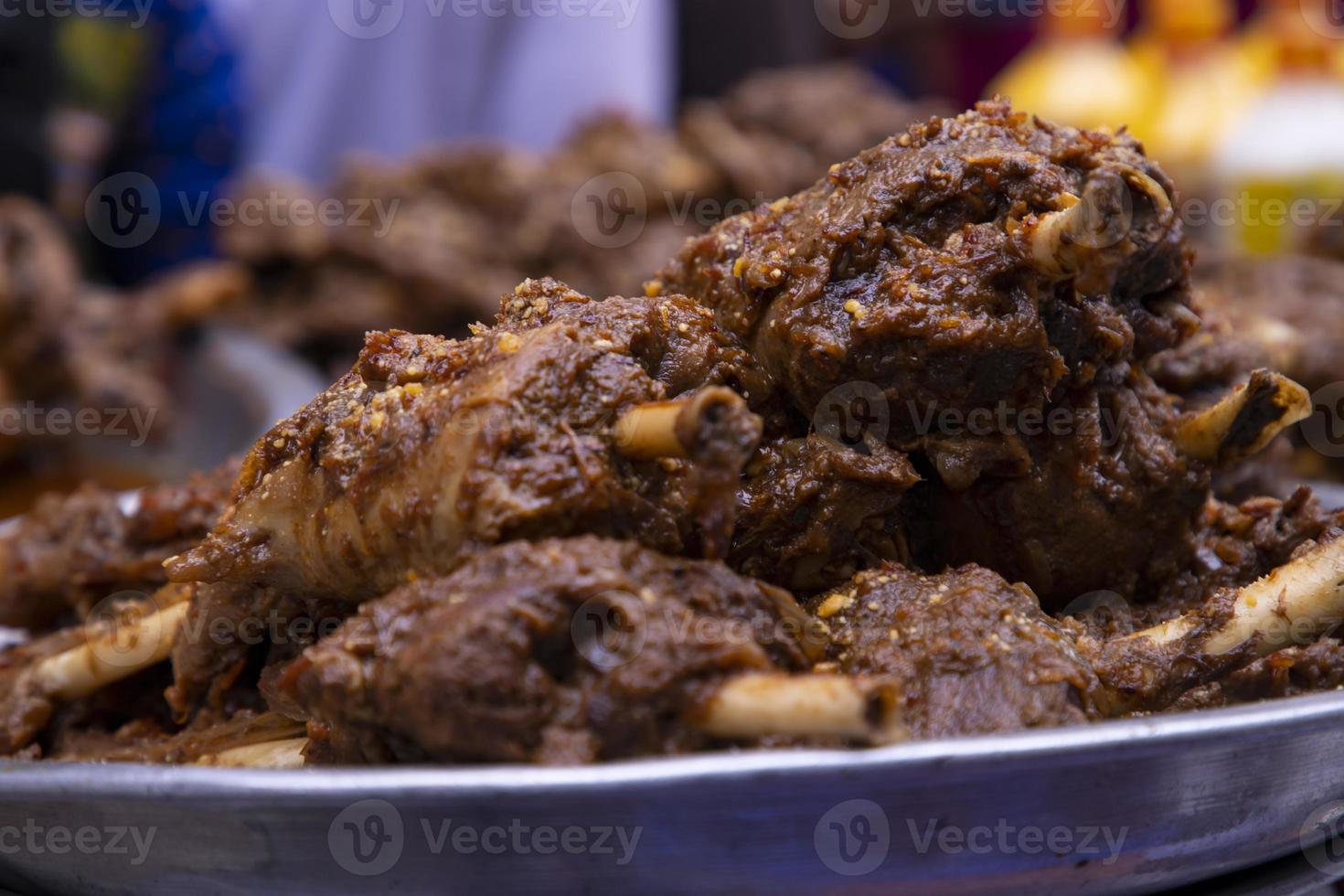Roasted leg pieces of mutton at a street food market in Dhaka, Bangladesh photo