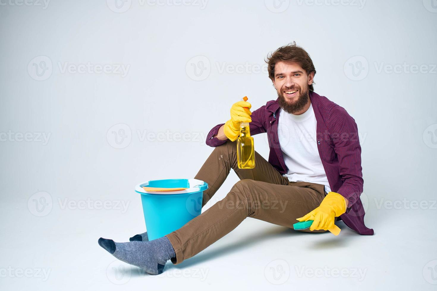 Cleaner sits on the floor with a bucket of homework service room interior photo