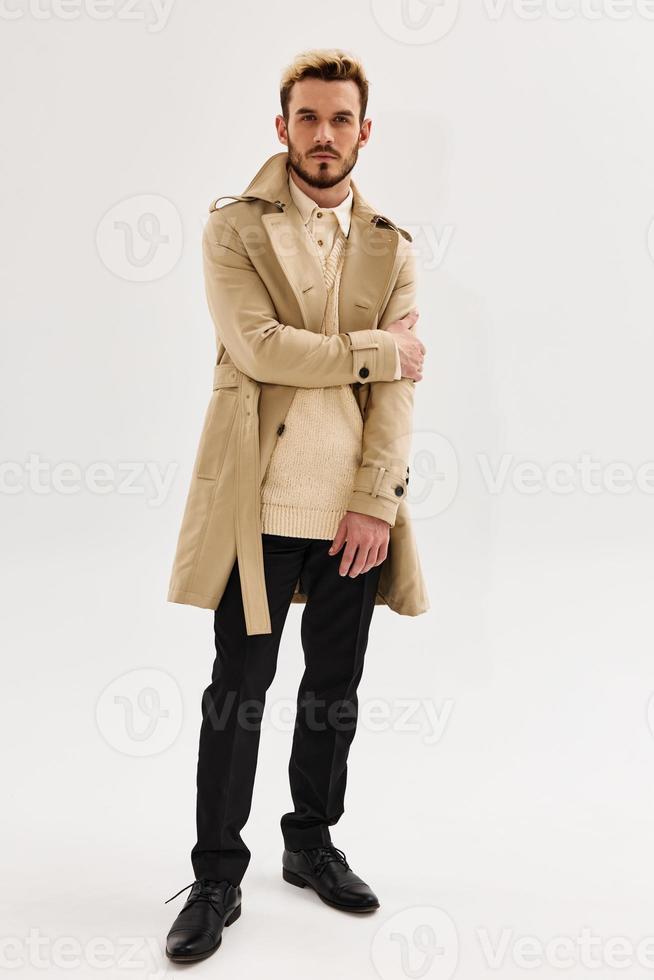 handsome man in coat fashion autumn style studio light background photo