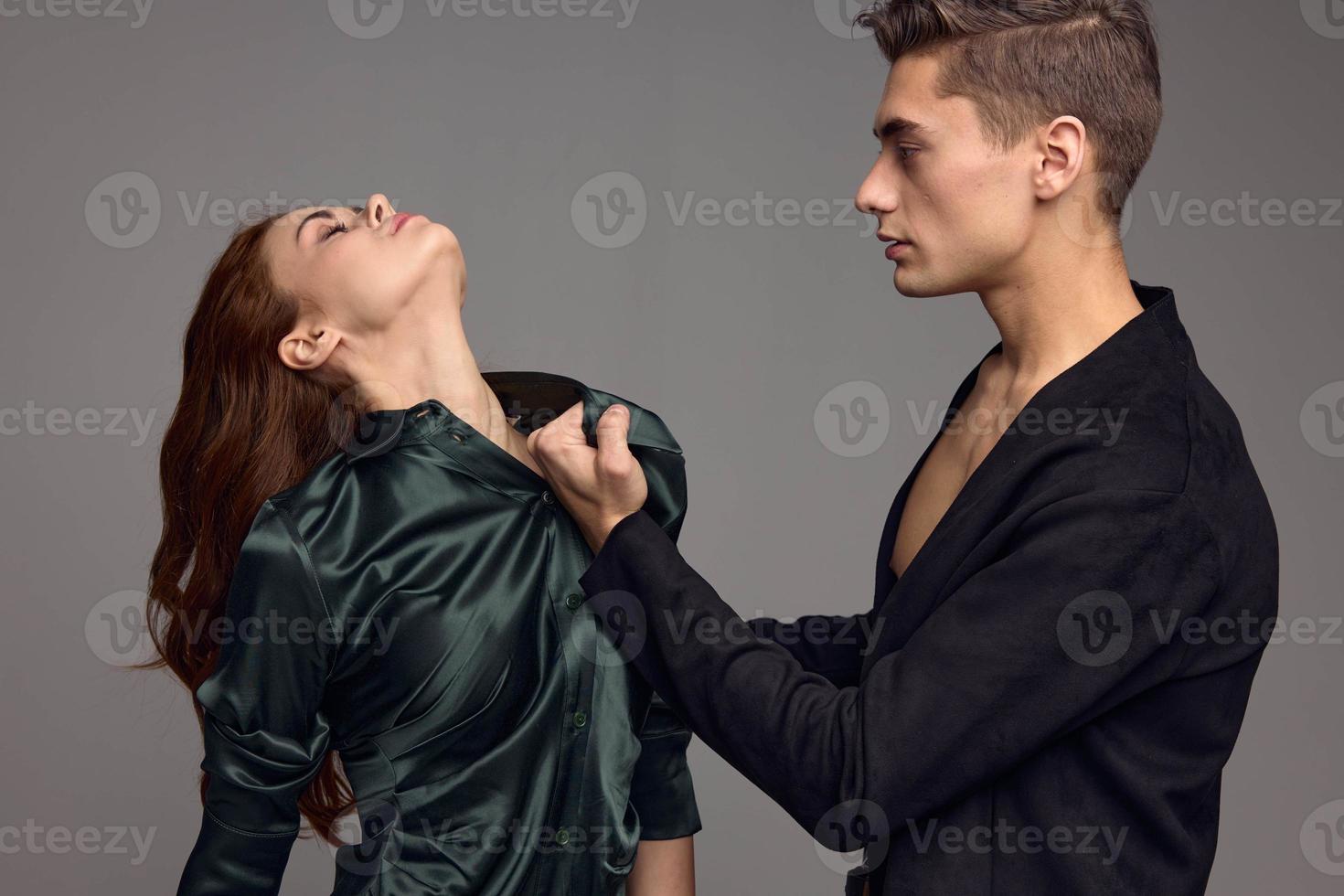 Strong man hurting woman on gray background domestic violence photo