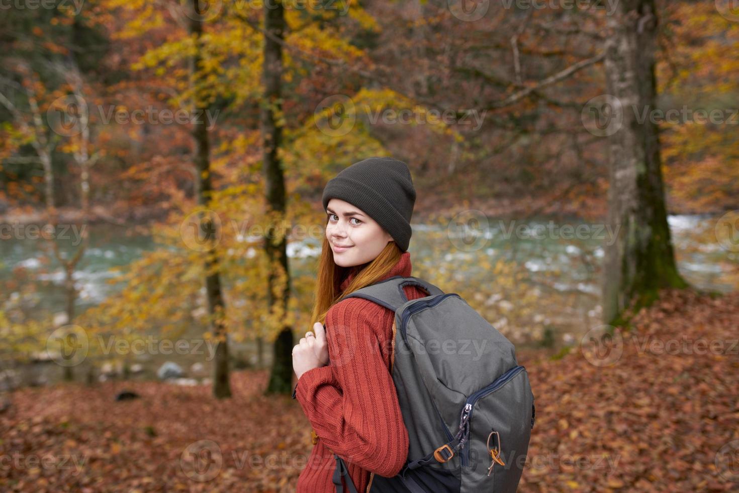 Autumn forest nature landscape tall trees and woman hiker with backpack photo