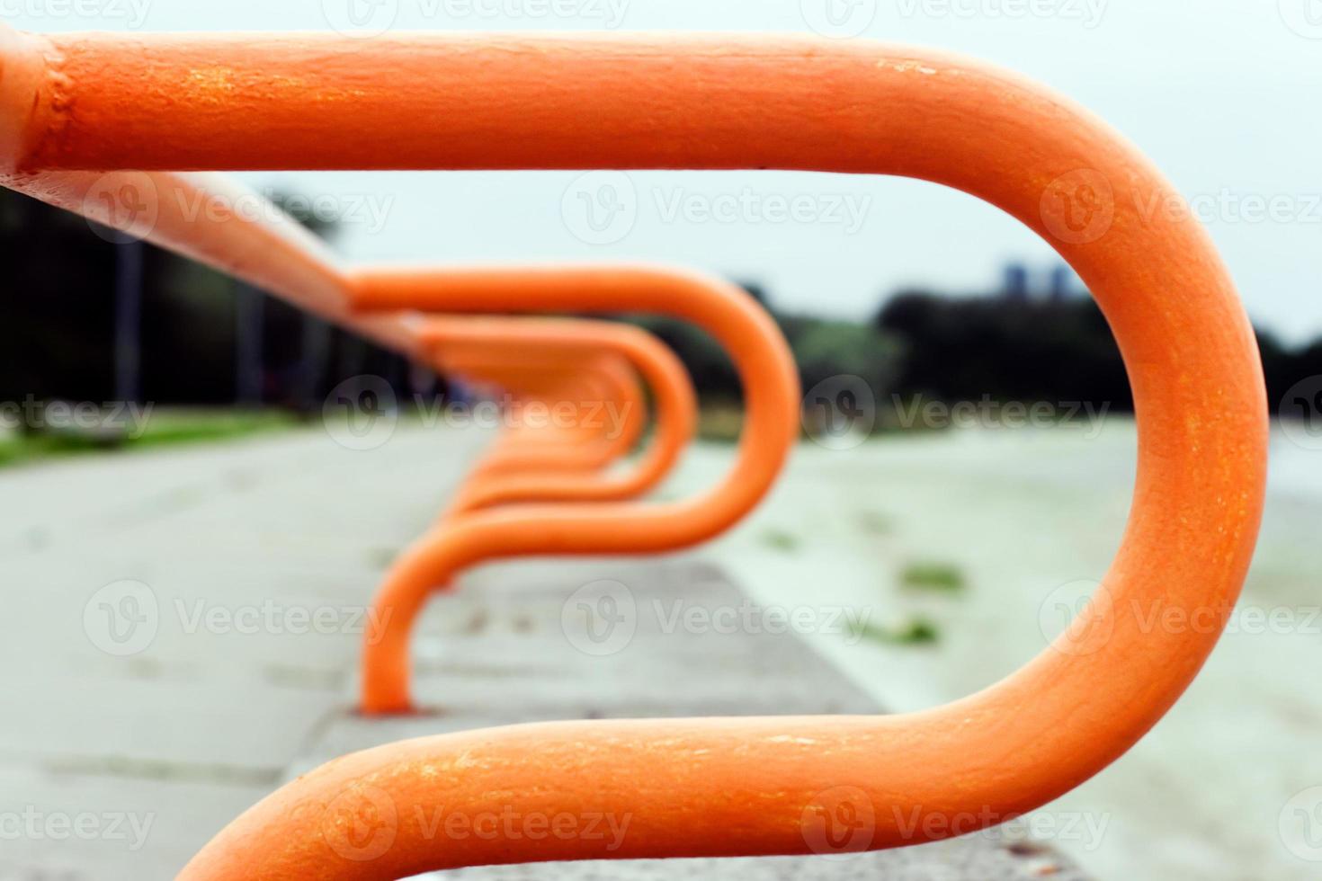 Abstract background. Blurred curved railing of the promenade going into the distance. The metal is painted orange. photo