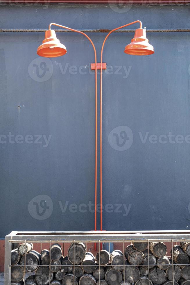 Two red lampshades on a gray wall in the street. Lamp in a wooden box on the background of a gray wall. photo
