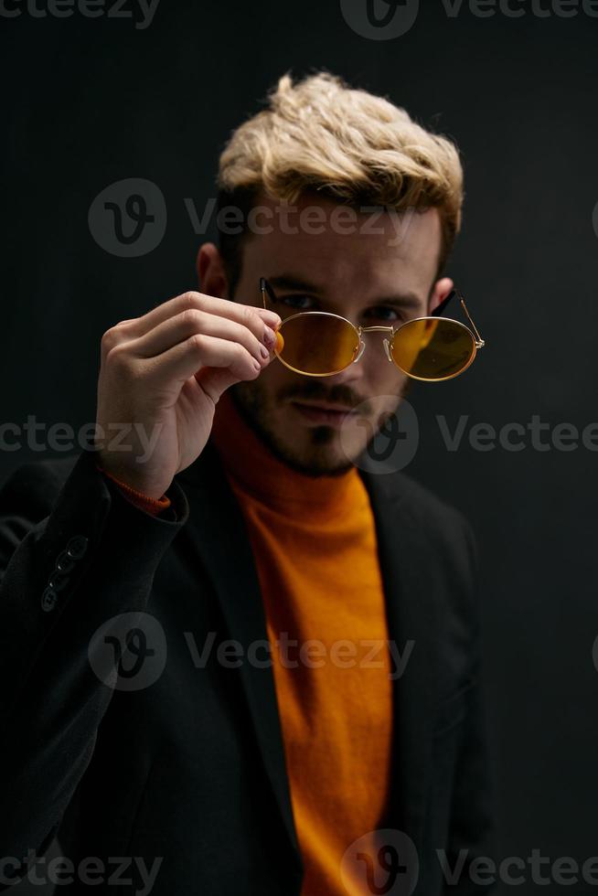 brutal man in glasses jacket and sweater blond dark background photo