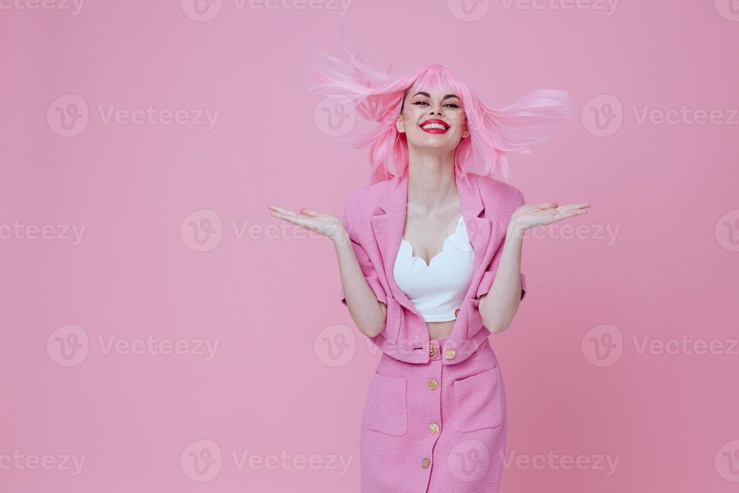 Pretty young female gesturing with hands pink jacket lifestyle glamor pink background unaltered photo