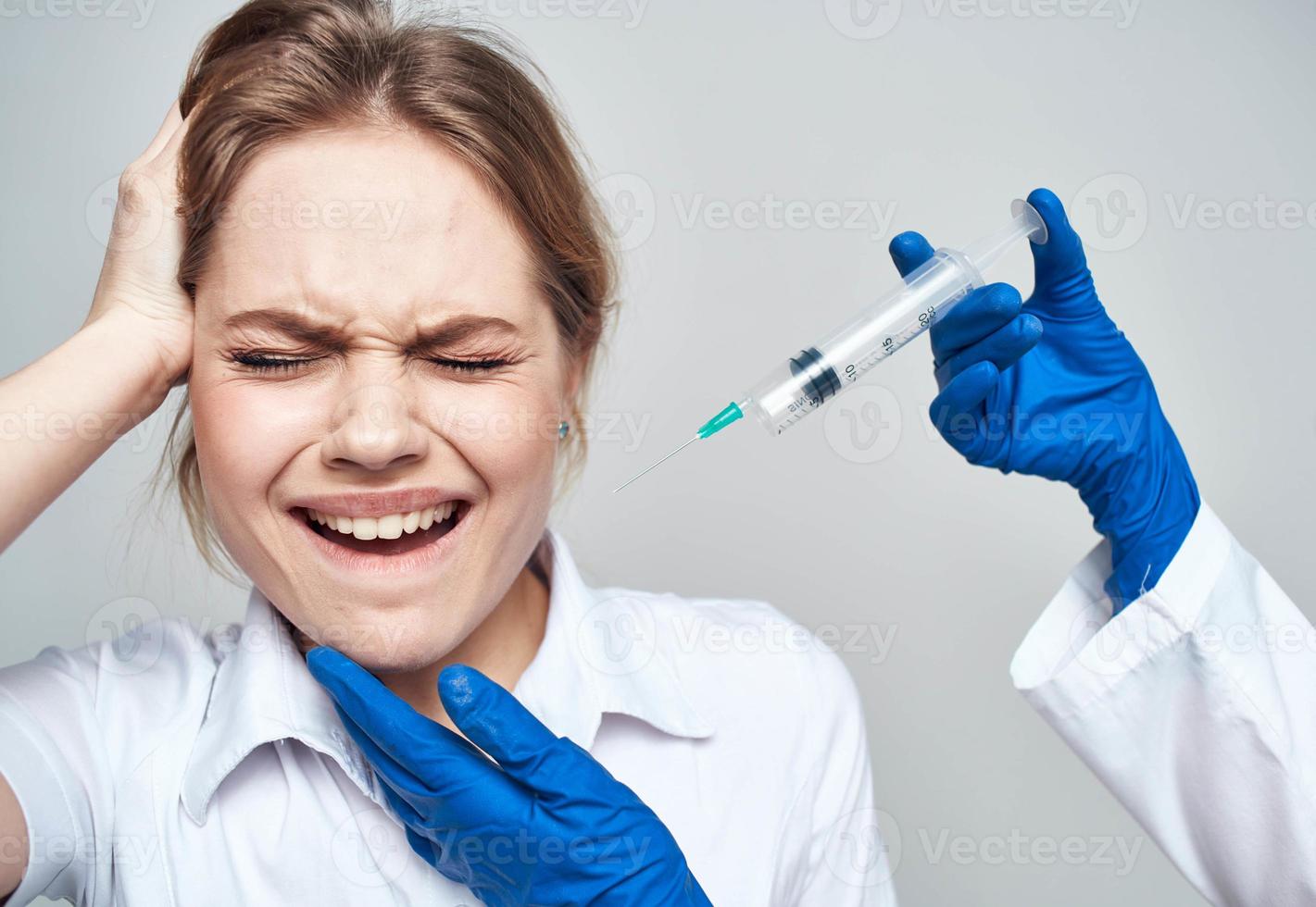 Scared woman and syringe in the hands of the doctor shock emotions model photo