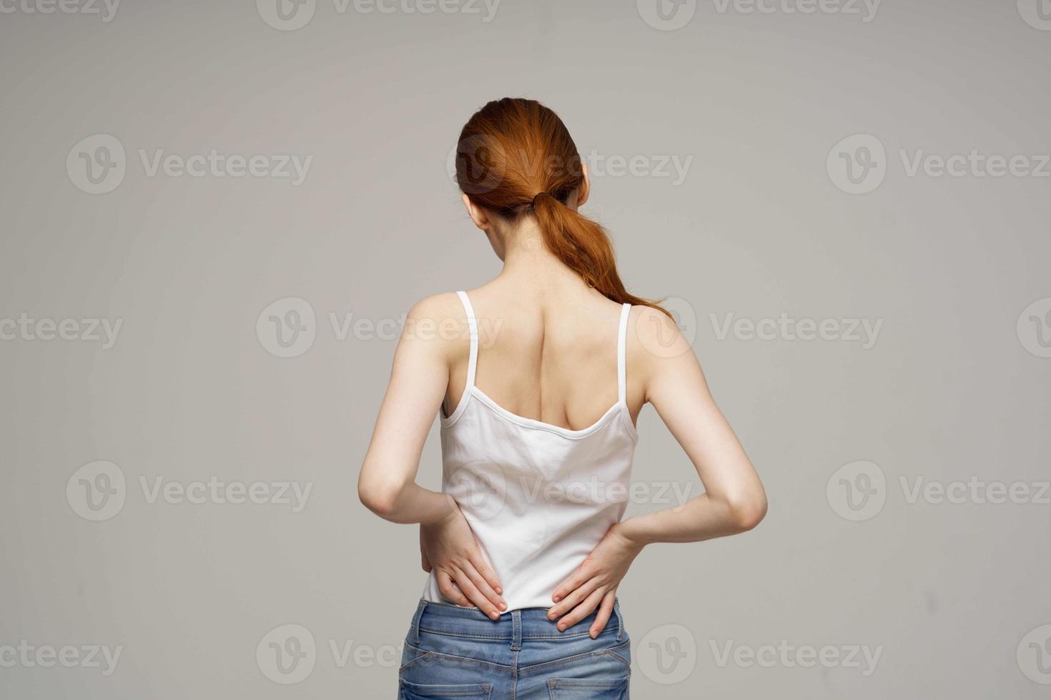 disgruntled woman back pain health problems osteoporosis light background photo