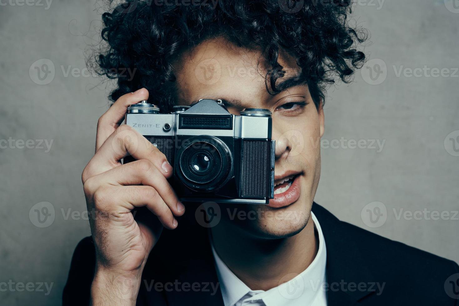 kinky guy with a camera in his hand black jacket white shirt hobby fun photo