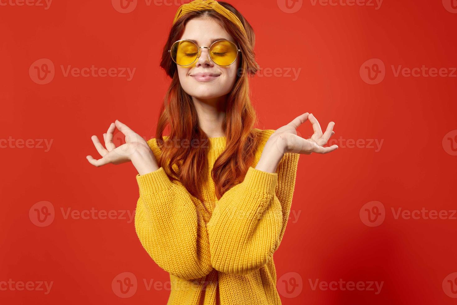 woman in yellow sweater hippie accessories retro style red background photo