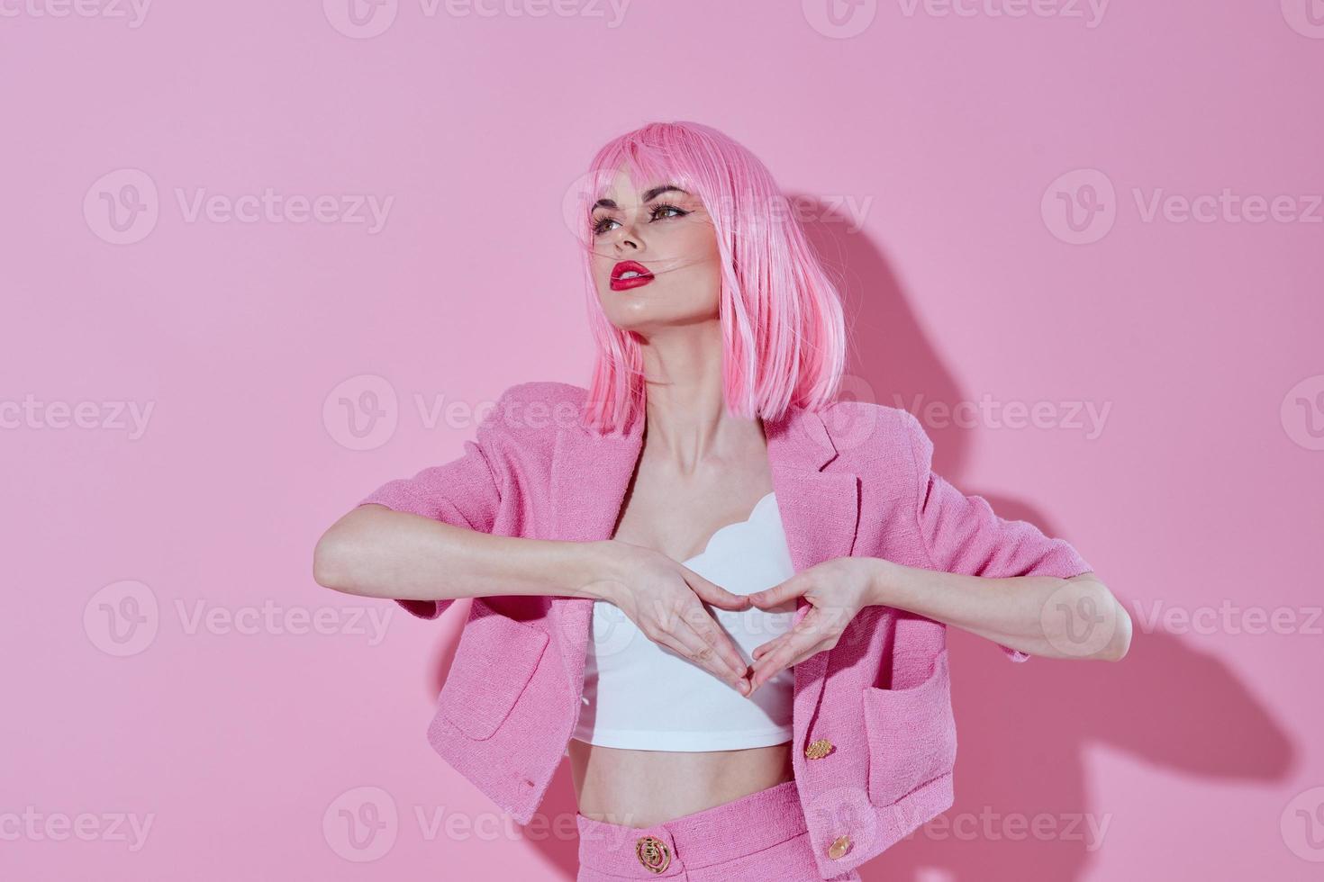 Young positive woman hold hands in the shape of a heart with a pink jacket monochrome shot photo