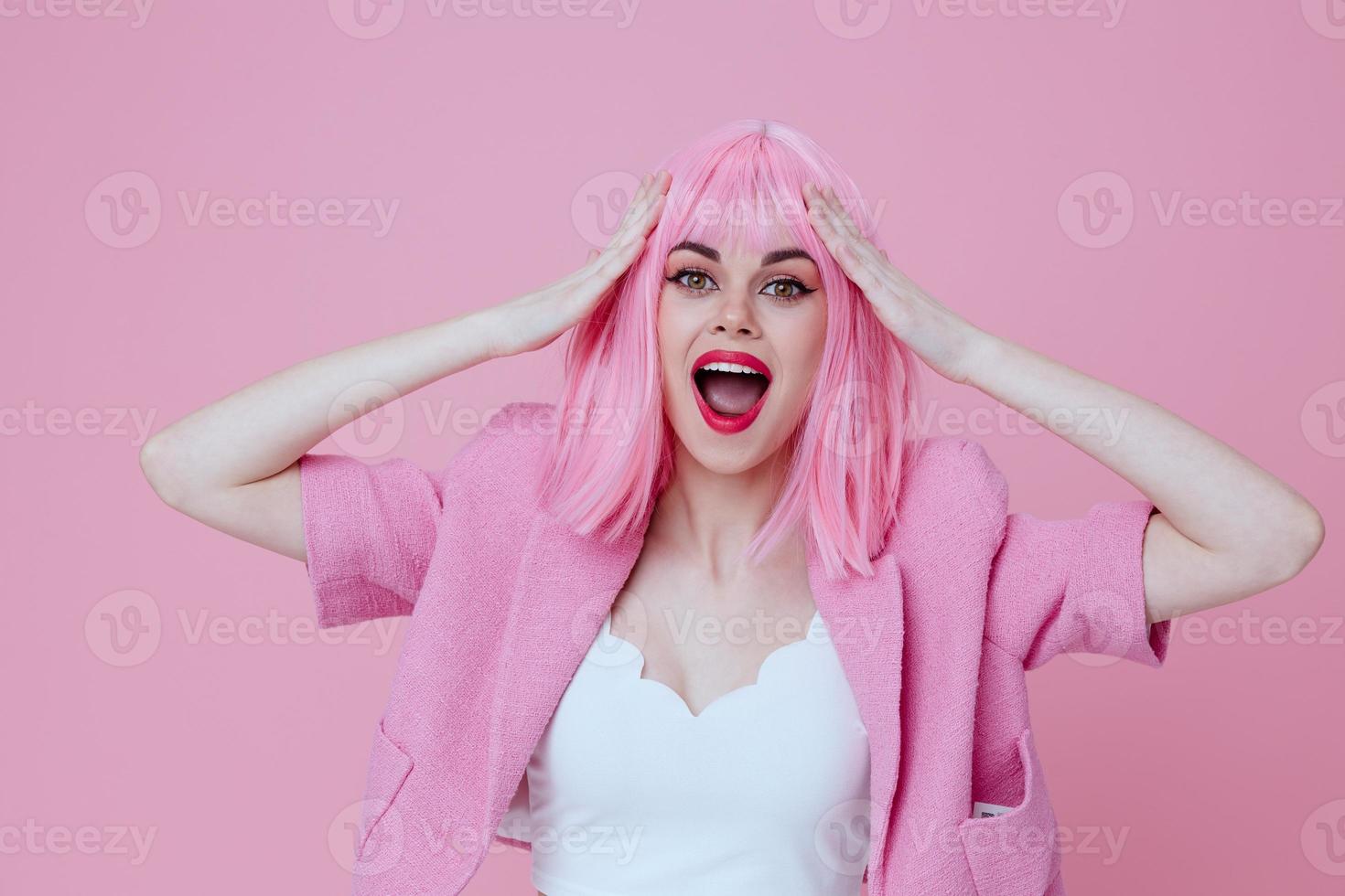 Pretty young female in a pink suit gesturing with his hands emotions fun pink background unaltered photo