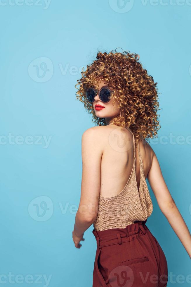 Pretty woman Fashion lifestyle dark sunglasses blue background curly hair photo